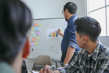 Male Teacher Wearing Glasses Guides Students With Presentation On Whiteboard