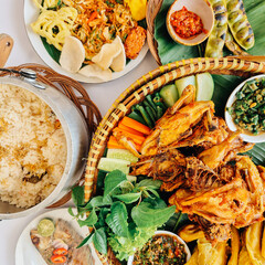 Traditional Indonesian Feast with Fried Chicken, Vegetables, and Rice