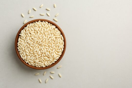 Bowl of puffed rice on a light grey surface, top-down perspective with space for writing