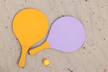 Beach tennis rackets and ball on sand. Active lifestyle, games and sports. Beach tennis set. Bright...