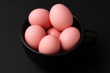 Pink eggs placed next to a black cup