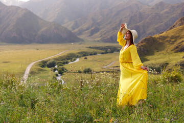 Young caucasian woman in yellow dress enjoying mountain view Altay Russia