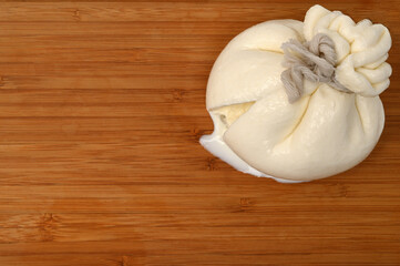 Creamy Italian traditional Burrata cheese on wooden board