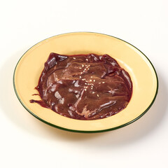 Fresh raw beef liver slices served in yellow plate with sprinkle of sesame seeds, showcasing rich red color and smooth texture, perfect for cooking or culinary preparation