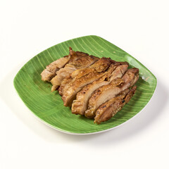 Grilled chicken slices served on green banana leaf patterned plate, showcasing golden brown, juicy texture, perfect for traditional or casual dining