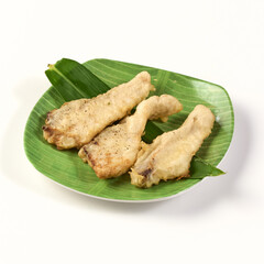 Crispy fried fish fillets served on green banana leaf plate, showcasing golden brown batter with light and crunchy texture, perfect for delicious meal