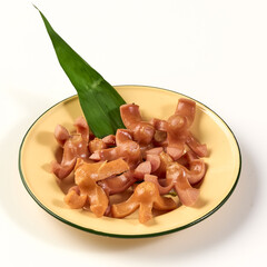 Fried sausage slices served on yellow plate with green leaf garnish, showcasing creative and appetizing presentation. dish is perfect as snack or appetizer