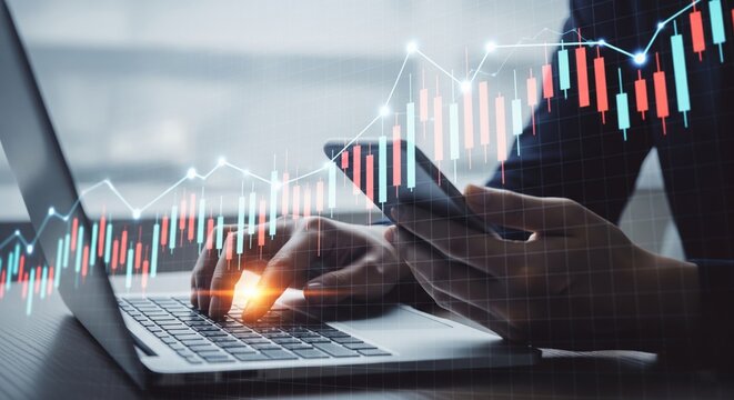 Businesswoman Analyzing Stock Market Candlestick Chart on Laptop and Smartphone