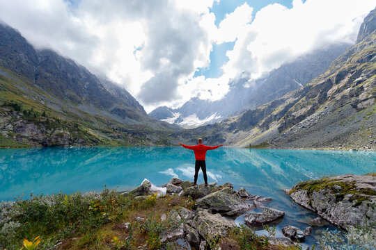 Hiker enjoys scenic mountain lake view with Incredible reflection in blue water. Concept outdoors trip for internet detox - Powered by Adobe