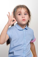 Little girl shows okay sign, cute and playful expression. Perfect for family, child, or education...