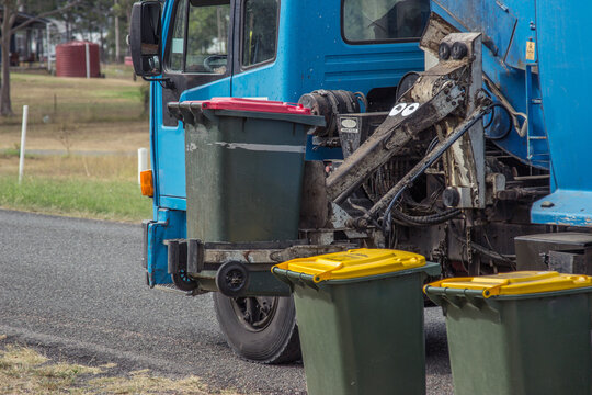 Rubbish from bins being collected by garbage truck