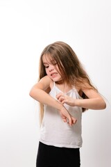 Young girl scratching her arm, showing discomfort and irritation. A candid shot of a child...