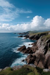Obraz premium Scenic coastal landscape with rocky cliffs and ocean waves under blue sky