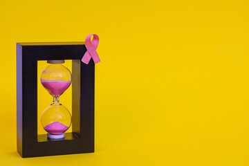 Concept image symbolizing breast cancer awareness and the urgency of early detection. A pink ribbon...