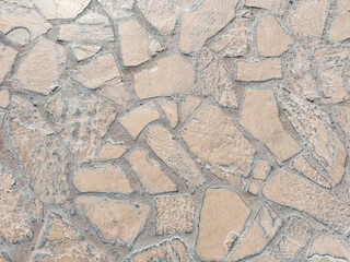 Close-up of irregular stone pavement surface with natural textured pattern, cracked shapes and grout lines, ideal for background, texture or architectural reference