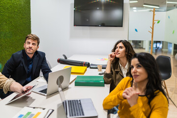 Group of young professionals attending a creative meeting in a coworking space, collaborating and exchanging ideas