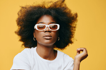 Stylish young woman with natural afro hairstyle, wearing white sunglasses and a minimalist t shirt...