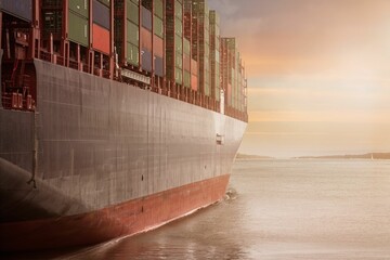 Cargo ship at sunset on calm sea.