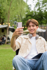Young non binary person having road trip and camping with friends drinking chocolate drink