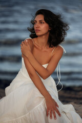 Ocean Breeze Elegance: Woman in White Dress on Coastal Rocks
A woman in a flowing white dress...