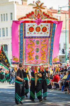 A large Chinese banner being carried in a parade