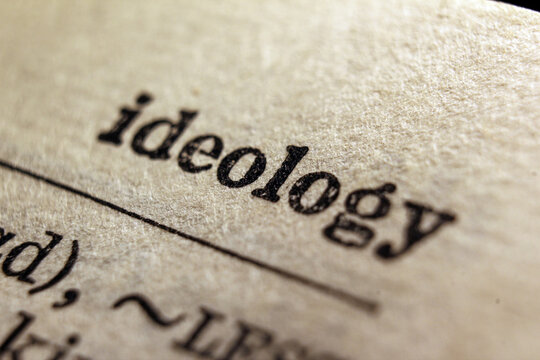 Word ideology on dictionary page, macro close-up	
