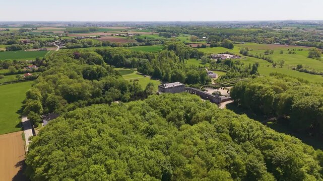 ch&acirc;teau seneffe amidst green cover surrounding trees distant town picturesque backdrop enhancing charm historic site left to right pans aerial of de belgium 