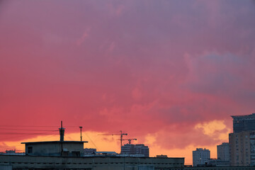 Urban Skyline Silhouette with Cranes at Colorful Dusk
