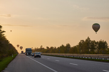 Hot Air Balloons Over Highway Traffic