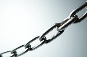 A close-up of a metal chain with interconnected links on a plain background
