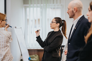 Business colleagues discussing ideas on a whiteboard during a formal meeting in a modern office...