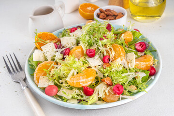 Salad bowl with lettuce, tangerines, nuts and cranberry
