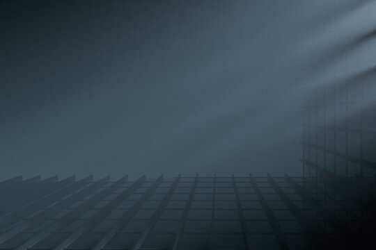 atmospheric view of a shadowy, grid-like structure partially obscured by fog or mist.  Sunlight streaks dramatically through the haze, illuminating parts of the architecture. 