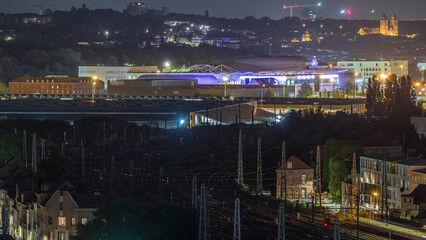 Aerial night timelapse of Brussels North station railway tracks with trains arriving and departing....