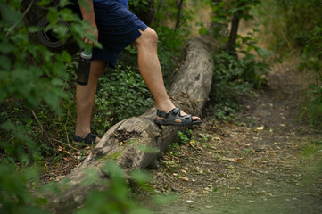 Naklejka premium A man with a backpack walks through the forest and the beach and does sports