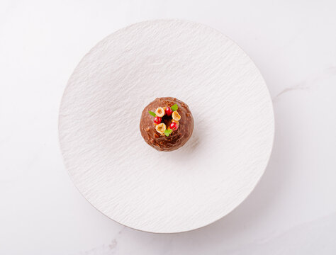 Dessert creation on a minimalistic white plate at a modern restaurant setting