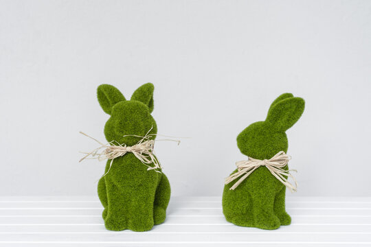 Two green bunnys on a plain background