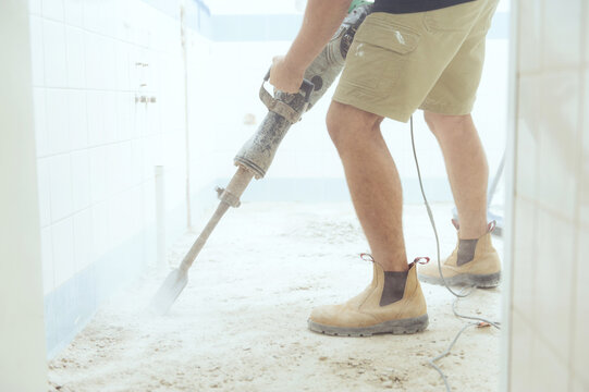 Workman jackhammering on construction site