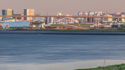 Naklejka premium Park Tejo and river timelapse in Lisbon with park of Nations district modern architecture on a background, Portugal.
