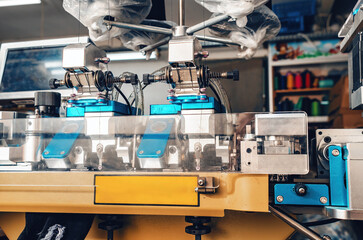 Textile industry, automatic knitting of socks. Machine for sewing the toe area of socks. Front view.