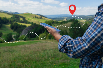 A close-up of a hiker's hands holding a smartphone, tracking a digital route marked by a dotted...