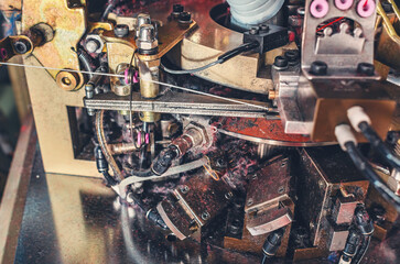 Dust from threads. Image of sock knitting machine in operation. Equipment in textile production.