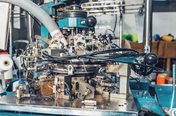 Exhaust pipe on industrial knitting machine. Close-up. Mechanisms of knitting factory. Production...