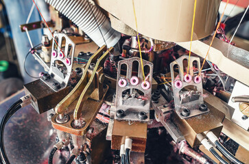 Part of machine with exhaust pipe on industrial knitting machine. Mechanisms of knitting factory.