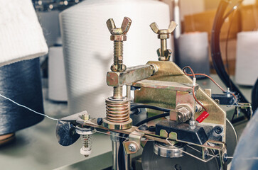 Thread tensioners located on spools on machines. Industrial enterprise for production of socks.