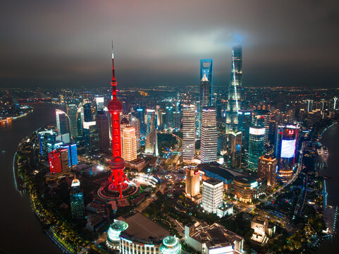 Shanghai, China - 21 June 2025: Aerial view of the vibrant cityscape, where the illuminated Oriental Pearl Tower stands out against the dark sky. - Powered by Adobe