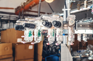 Thread tensioners located on spools on machines. Industrial enterprise for the production of socks.