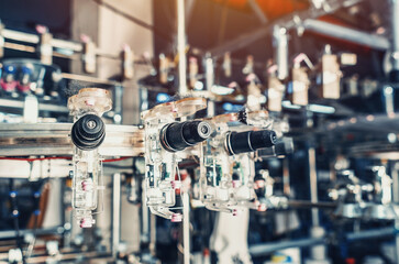 Thread tensioners located on spools on machines. Industrial enterprise for the production of socks.