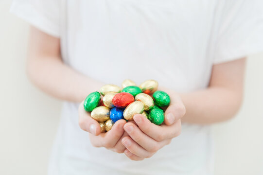 Child's hands holding coloured mini easter eggs