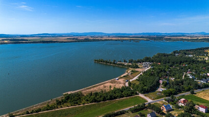 Reservoir with a dam against the backdrop of the Krkanosz Mountains. Poland, Mietkow, Bozhigniew. Drone view.